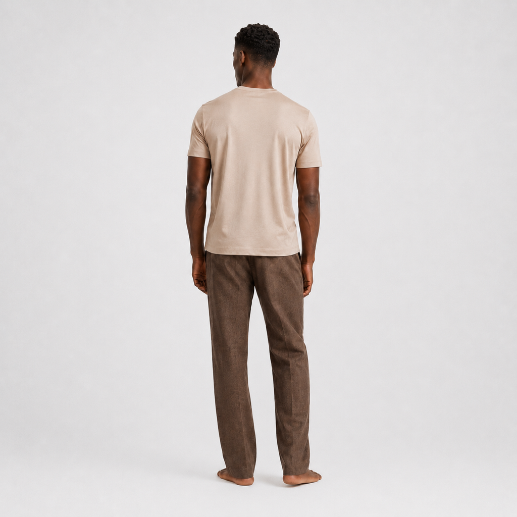 Model trägt beigefarbenes Herren T-Shirt im Clean Fit kombiniert mit einer dunklen Hose | Malviro