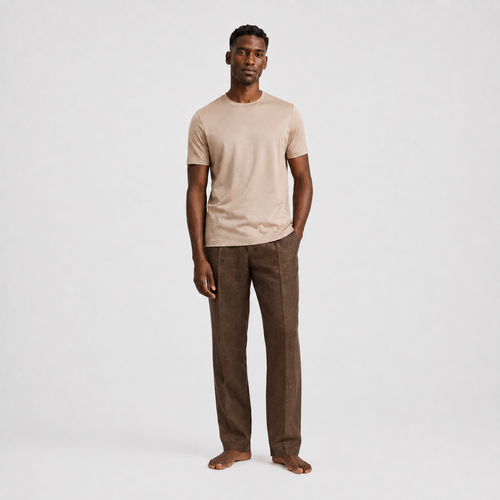 Model trägt beigefarbenes Herren T-Shirt im Clean Fit kombiniert mit einer dunklen Hose | Malviro
